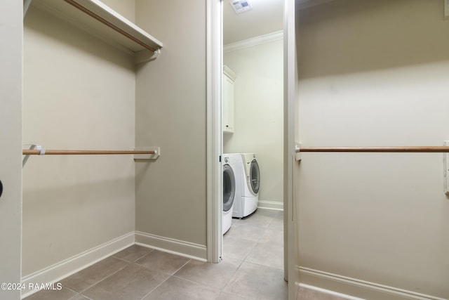 laundry area with washer and dryer, crown molding, cabinets, and light tile patterned flooring