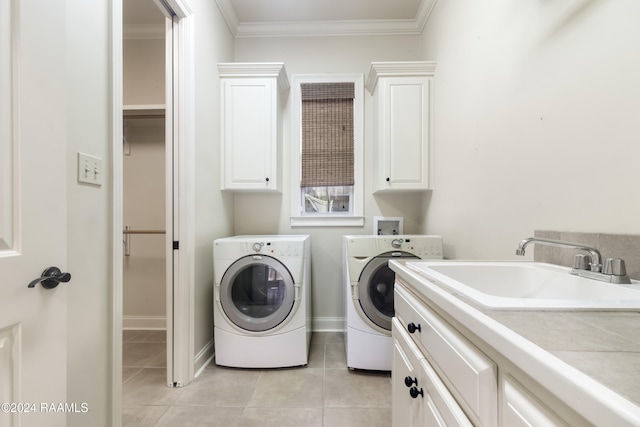 clothes washing area with washing machine and clothes dryer, sink, cabinets, light tile patterned floors, and ornamental molding