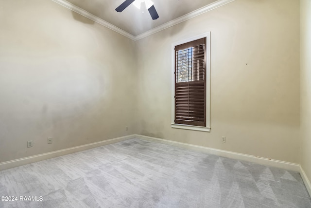 spare room featuring ceiling fan, light colored carpet, and ornamental molding