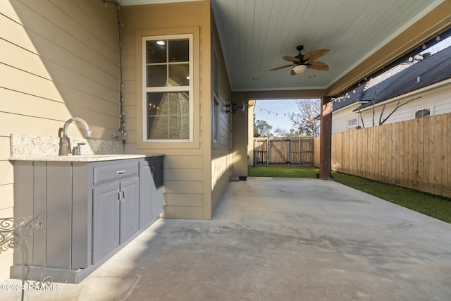 view of patio / terrace with ceiling fan, exterior kitchen, and sink