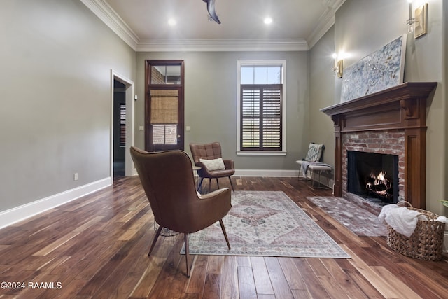 sitting room with dark hardwood / wood-style floors, ornamental molding, and a fireplace