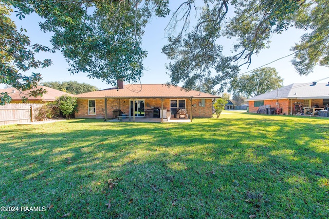 back of property featuring a yard and a patio