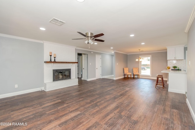 unfurnished living room with dark hardwood / wood-style flooring, a brick fireplace, ceiling fan, and crown molding