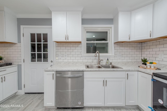 kitchen featuring backsplash, white cabinets, sink, ornamental molding, and stainless steel appliances