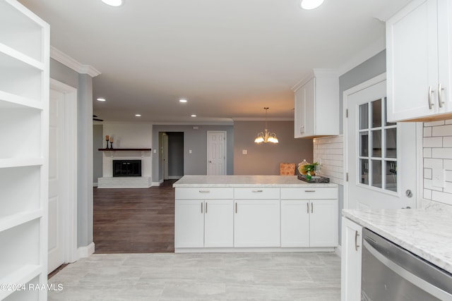 kitchen featuring pendant lighting, backsplash, white cabinetry, and stainless steel dishwasher