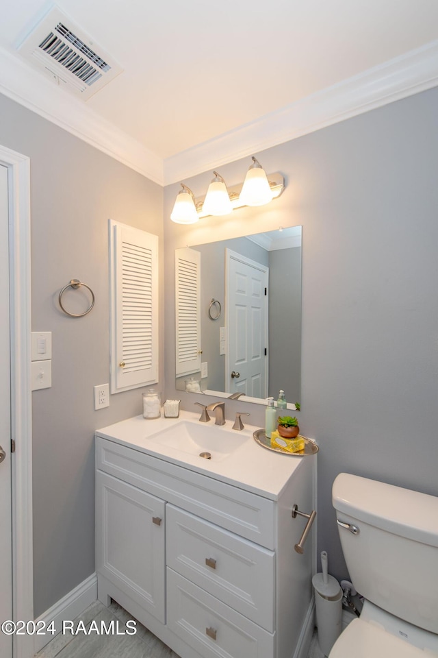 bathroom featuring vanity, toilet, and ornamental molding