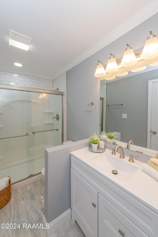 bathroom with crown molding, vanity, an enclosed shower, and toilet