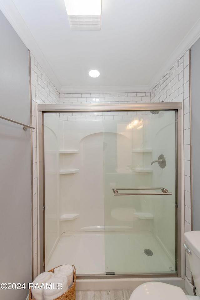 bathroom with crown molding, an enclosed shower, and toilet