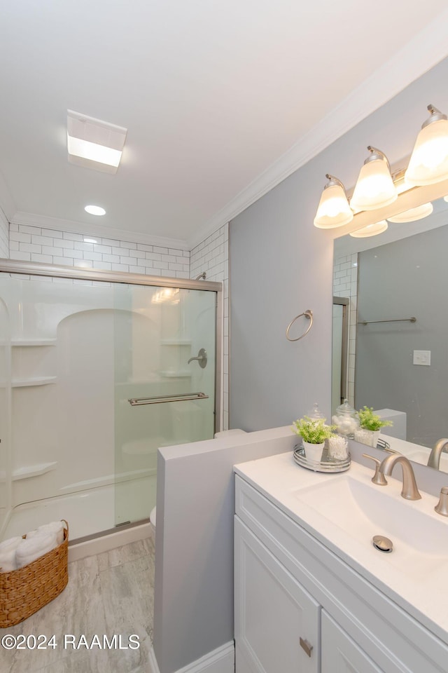 bathroom with hardwood / wood-style flooring, vanity, a shower with shower door, and ornamental molding