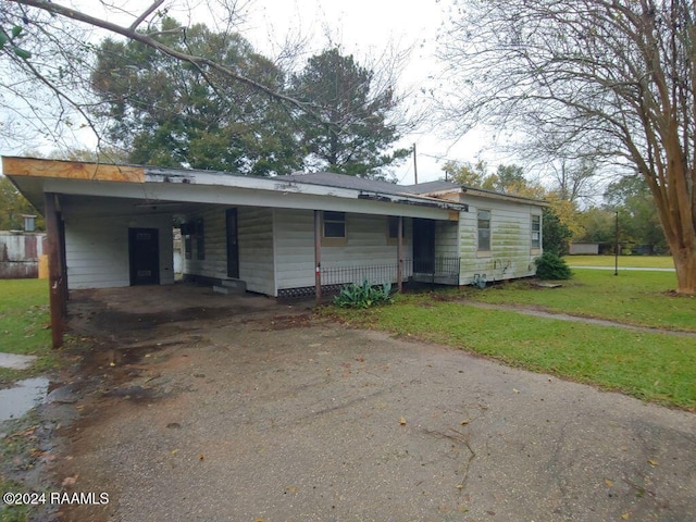 view of front of property featuring a front yard and a carport