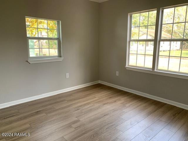 unfurnished room featuring baseboards and wood finished floors