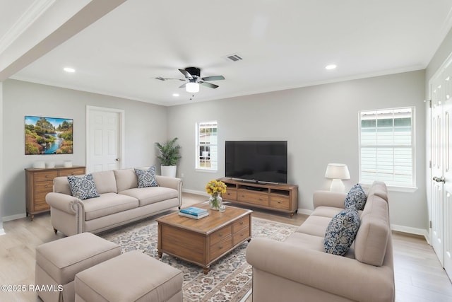 living room featuring visible vents, crown molding, and light wood finished floors