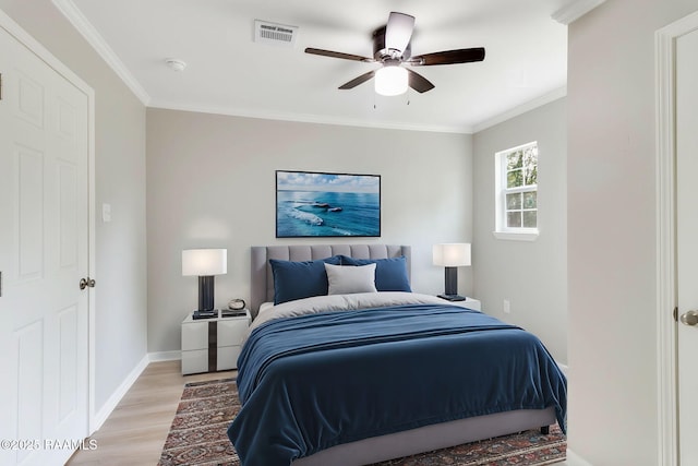 bedroom with baseboards, visible vents, a ceiling fan, ornamental molding, and light wood-style floors