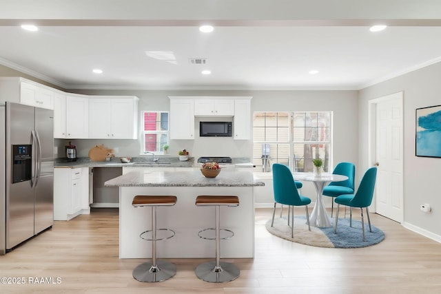 kitchen featuring a kitchen island, a sink, light wood-type flooring, stainless steel refrigerator with ice dispenser, and built in microwave