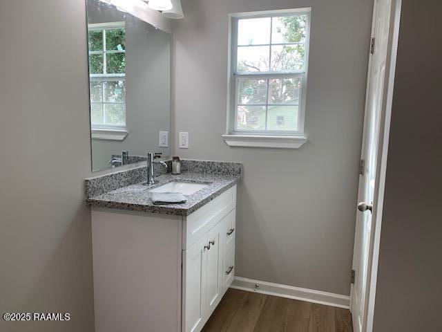 bathroom featuring wood finished floors, vanity, and baseboards