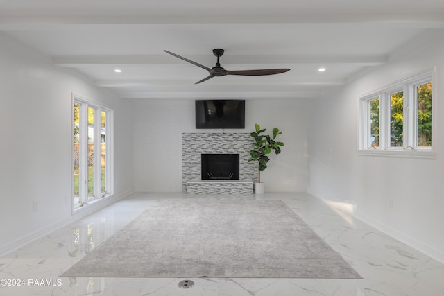 unfurnished living room featuring beamed ceiling, ceiling fan, and a fireplace