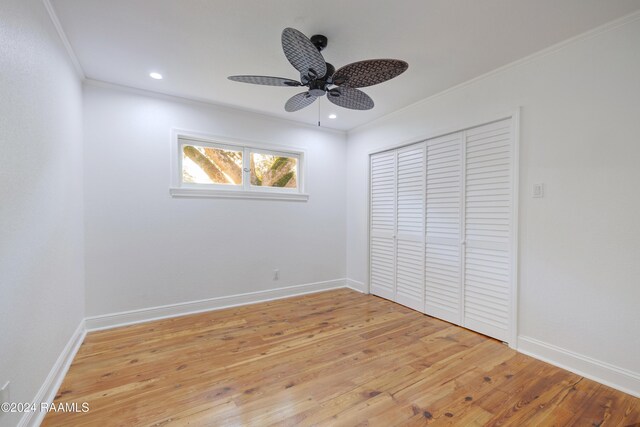 unfurnished bedroom with ceiling fan, light wood-type flooring, ornamental molding, and a closet