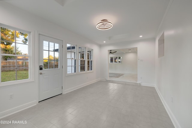 spare room with ceiling fan, light tile patterned flooring, and crown molding