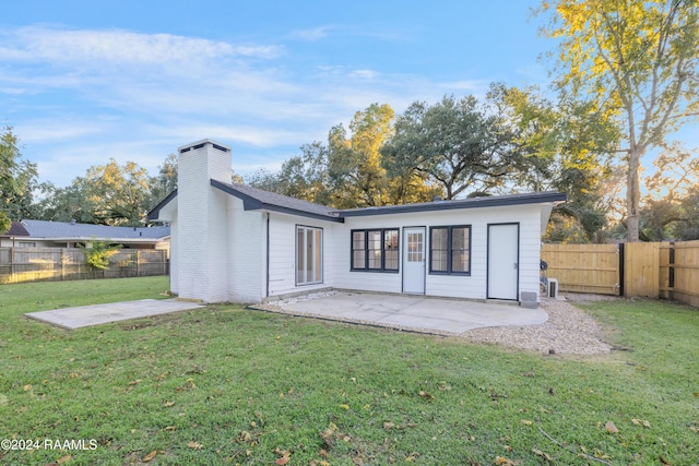 back of property featuring a patio and a lawn