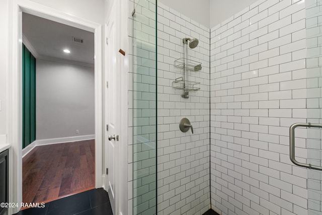 bathroom featuring wood-type flooring, walk in shower, and crown molding