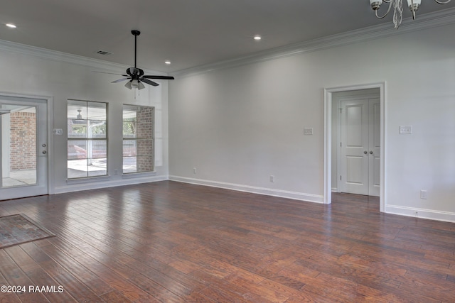 empty room featuring dark hardwood / wood-style flooring, ceiling fan with notable chandelier, and ornamental molding