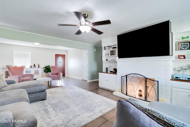 living room featuring built in shelves, ceiling fan, light tile patterned floors, and a brick fireplace