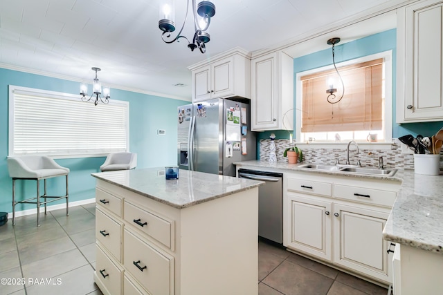 kitchen with sink, light stone counters, pendant lighting, a kitchen island, and appliances with stainless steel finishes