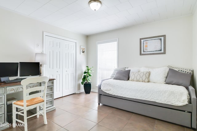 tiled bedroom with a closet