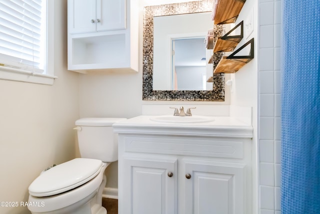 bathroom featuring curtained shower, vanity, and toilet