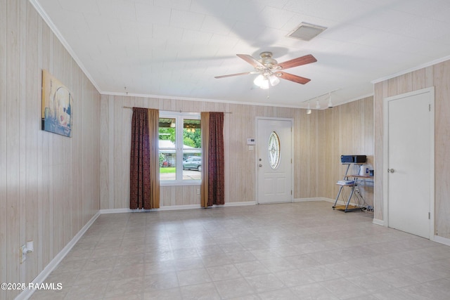 foyer with ceiling fan and crown molding