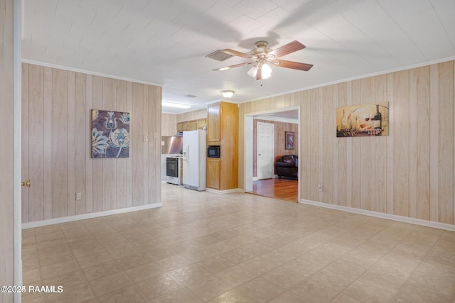 interior space featuring ceiling fan, ornamental molding, and wood walls