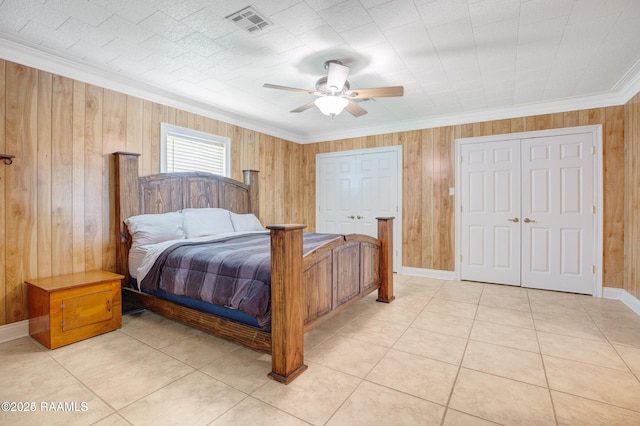 bedroom with ceiling fan, crown molding, light tile patterned floors, and wooden walls