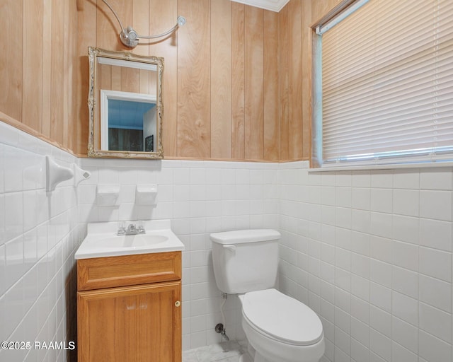 bathroom with vanity, tile walls, and toilet