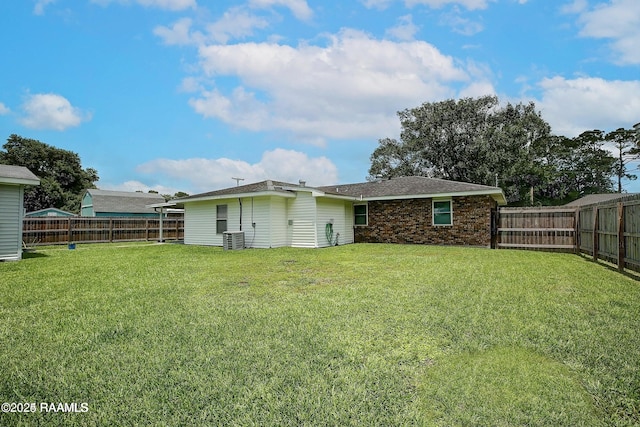 back of property with cooling unit and a yard