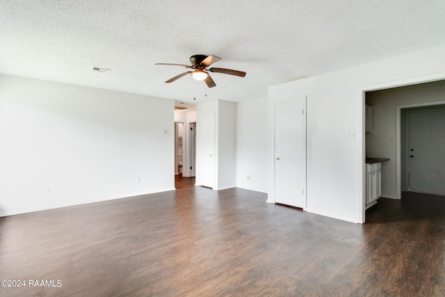 empty room featuring a textured ceiling, ceiling fan, and dark hardwood / wood-style floors