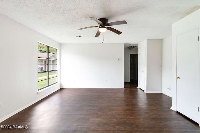 unfurnished room with ceiling fan, dark wood-type flooring, and a textured ceiling