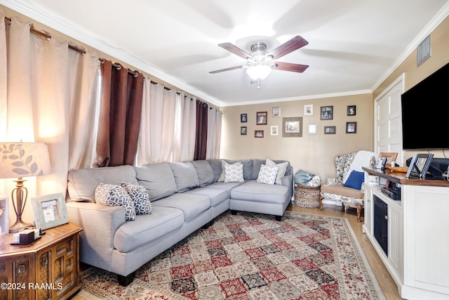 living room featuring crown molding, light wood-type flooring, and ceiling fan