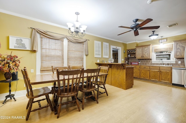 dining space with sink, crown molding, and light hardwood / wood-style flooring