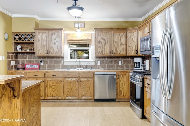 kitchen with sink, crown molding, stainless steel appliances, decorative light fixtures, and light wood-type flooring