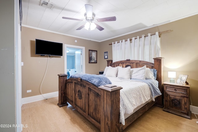 bedroom featuring ensuite bath, ornamental molding, light hardwood / wood-style floors, and ceiling fan