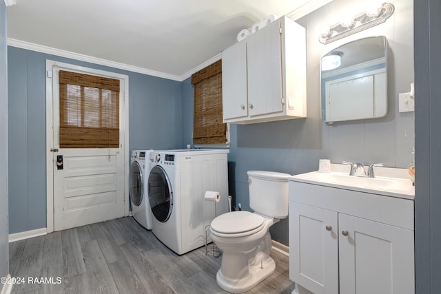 clothes washing area with sink, light hardwood / wood-style flooring, ornamental molding, and independent washer and dryer