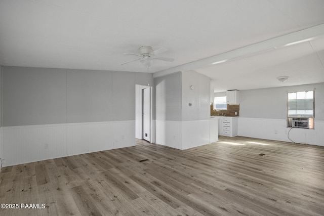 spare room featuring ceiling fan, cooling unit, and light hardwood / wood-style floors