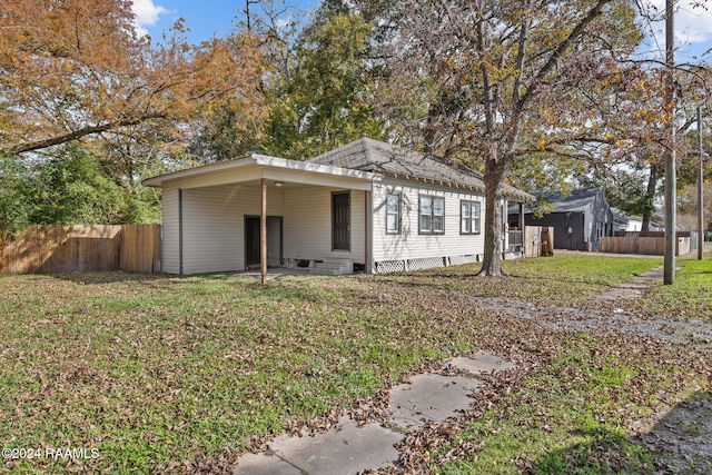 view of front of property with a front lawn and a carport