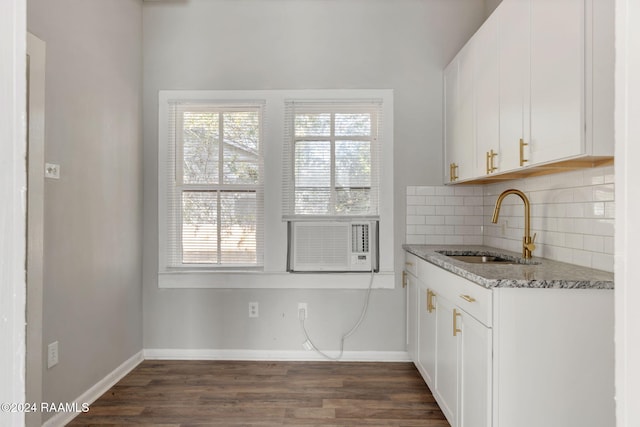 kitchen featuring light stone counters, sink, white cabinets, and dark wood-type flooring