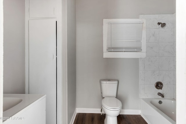 full bathroom featuring hardwood / wood-style floors, vanity, toilet, and tiled shower / bath