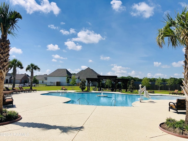 view of swimming pool featuring pool water feature, a patio, a pergola, and a lawn