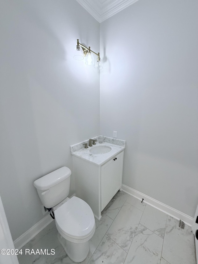 bathroom with vanity, crown molding, and toilet