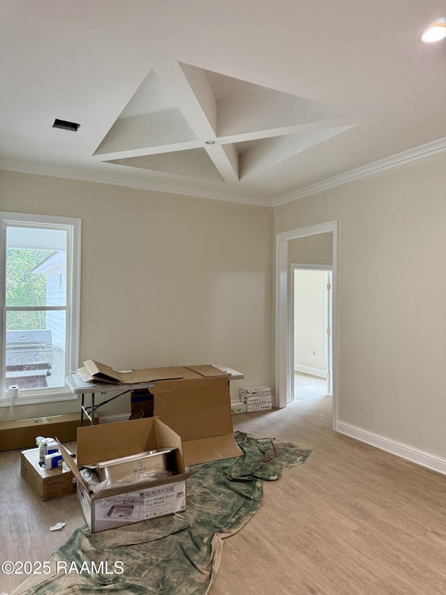 interior space featuring coffered ceiling, beamed ceiling, crown molding, and light hardwood / wood-style flooring