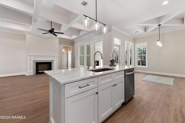 kitchen featuring open floor plan, a sink, visible vents, and baseboards