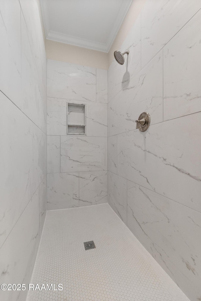 full bathroom featuring tiled shower and crown molding